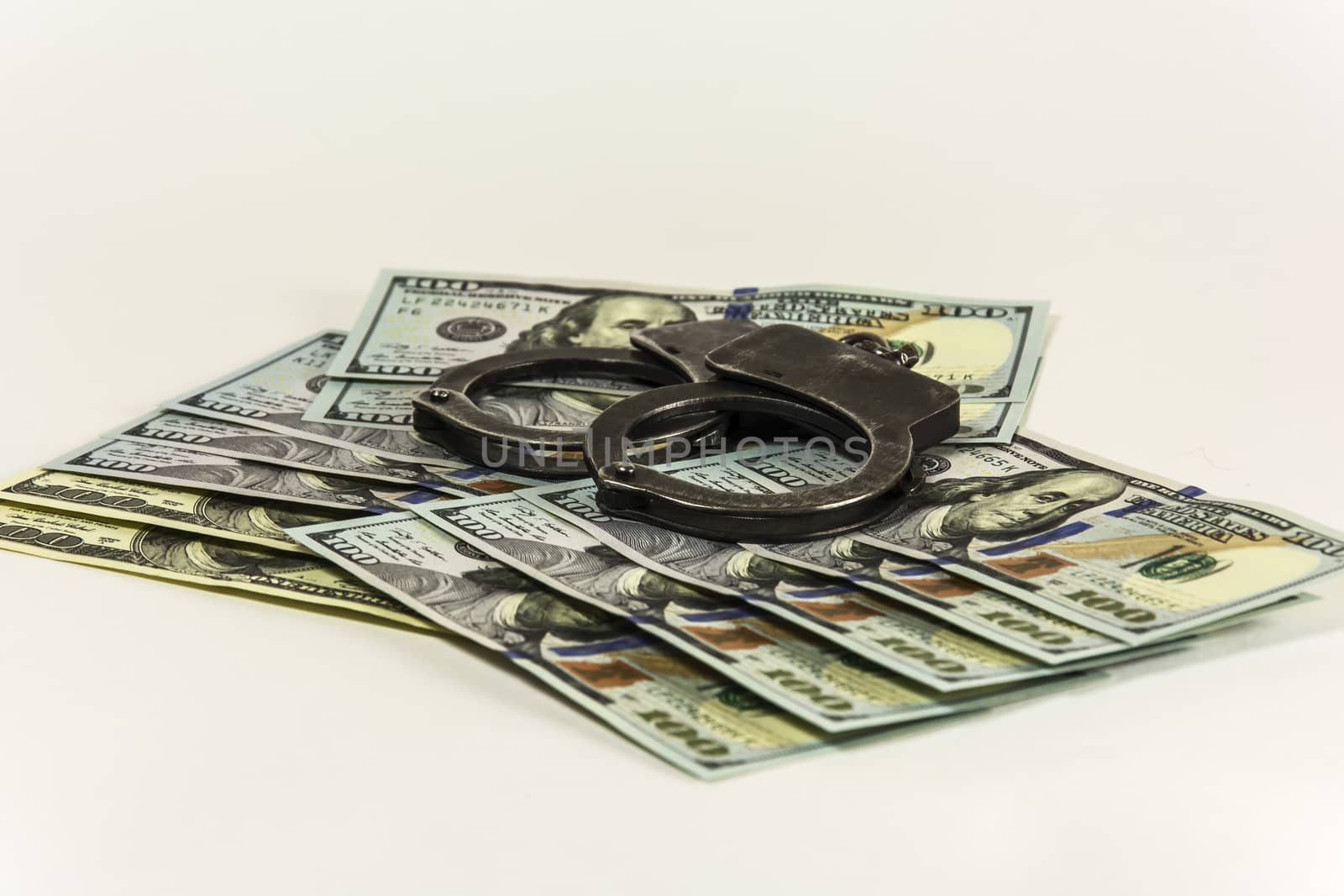 Metal handcuffs on banknotes US dollars by Grommik