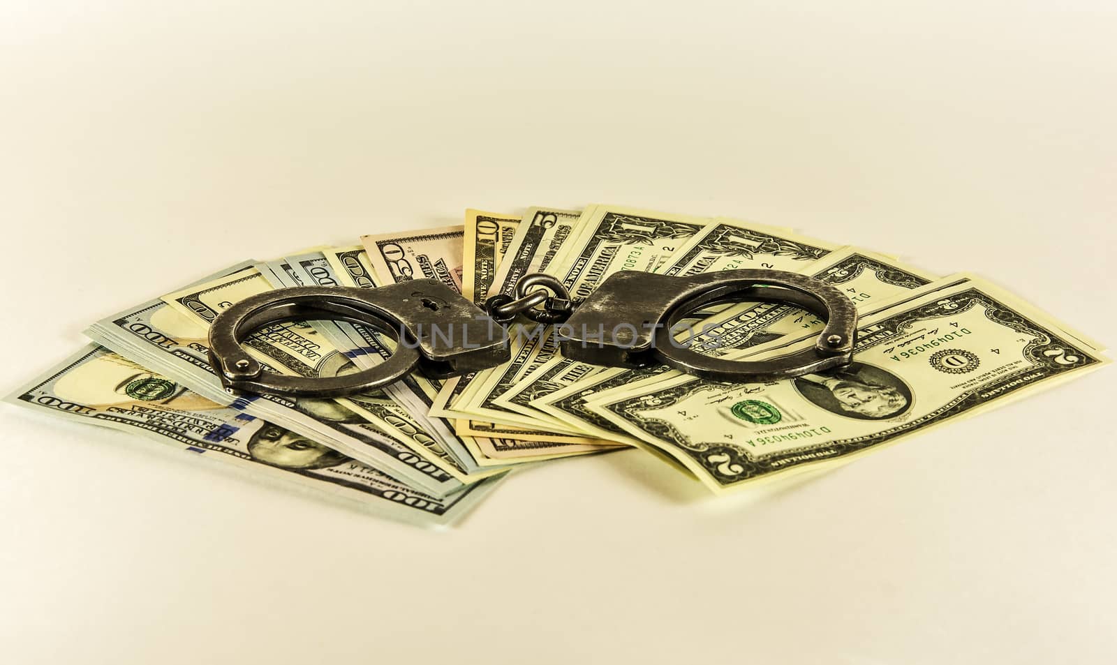 Metal handcuffs on the banknotes of US dollars by Grommik