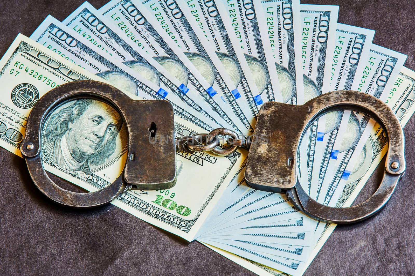 Metal handcuffs on the US currency bills

