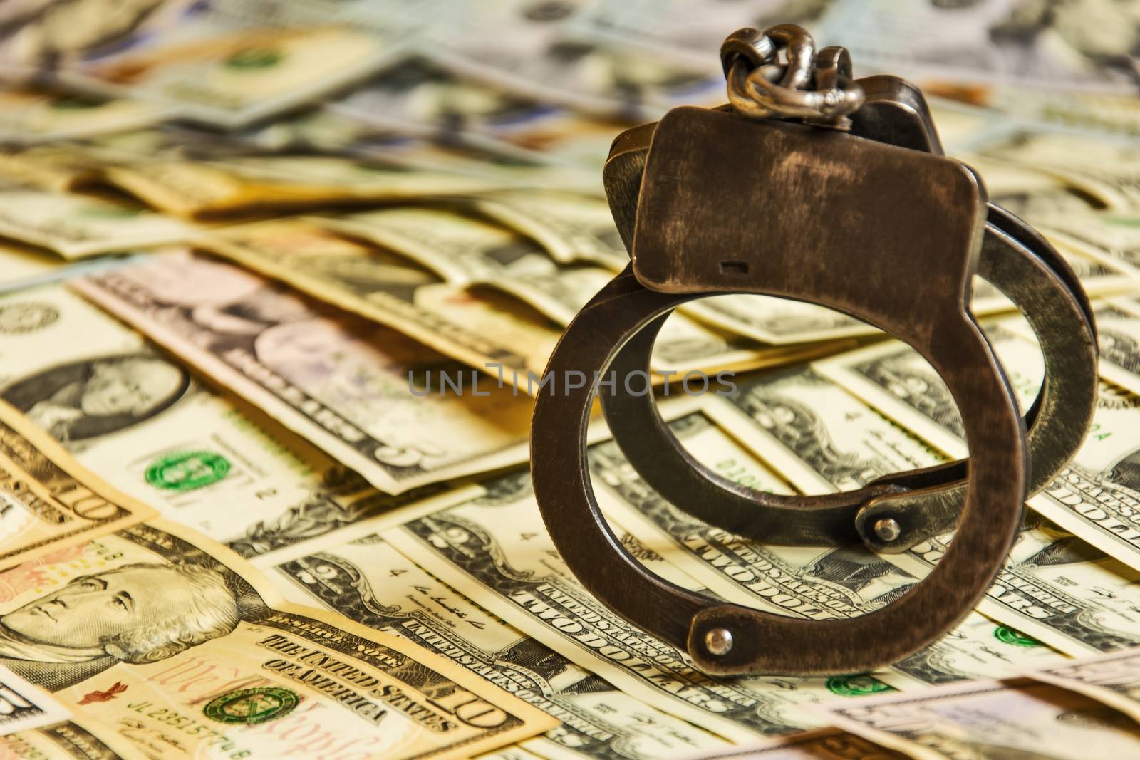 Metal handcuffs on the US currency bills

