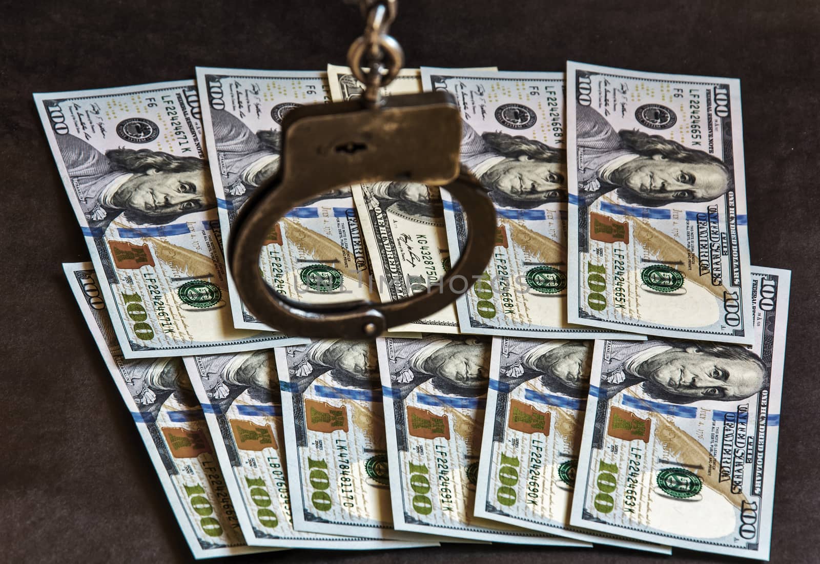 Handcuffs on one hundred banknotes of US dollars by Grommik