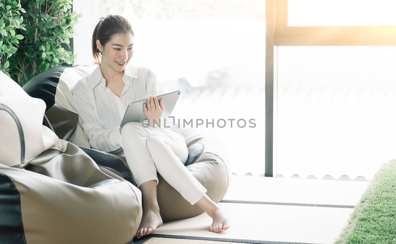 Asian woman usgin smart tablet at home.