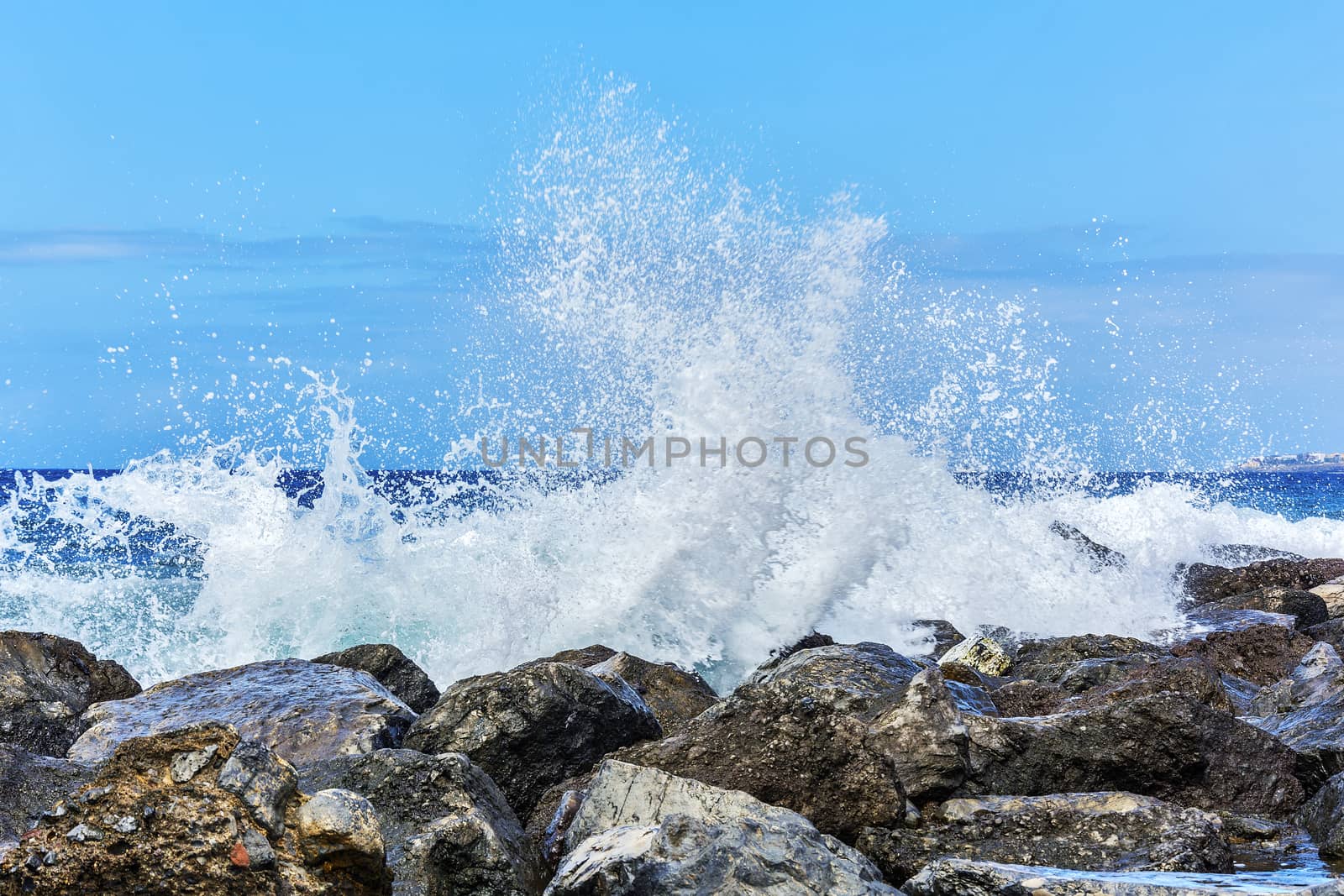 Waves breaking in splashes on the coastal rocks by Grommik