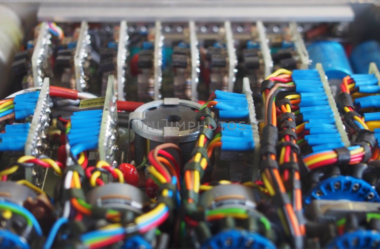 selective focus image of complex colored wiring and connectors joining circuit boards with electrical components