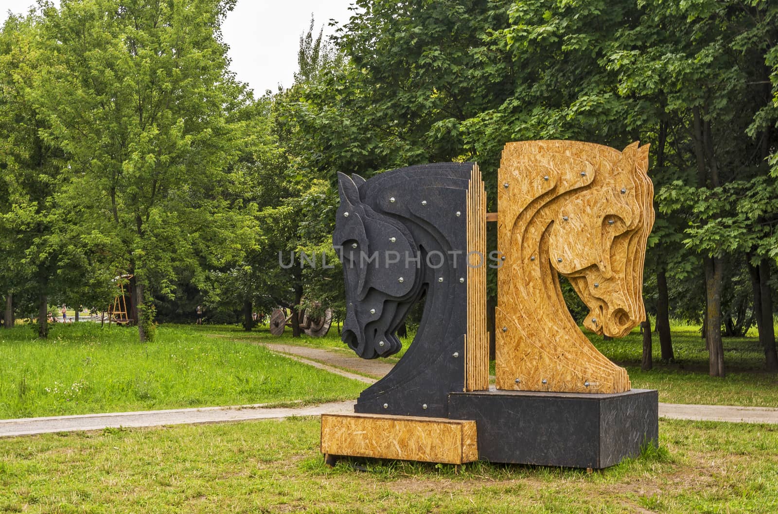 Sculpture made of plywood two chess pieces - black and white horses set in a city park