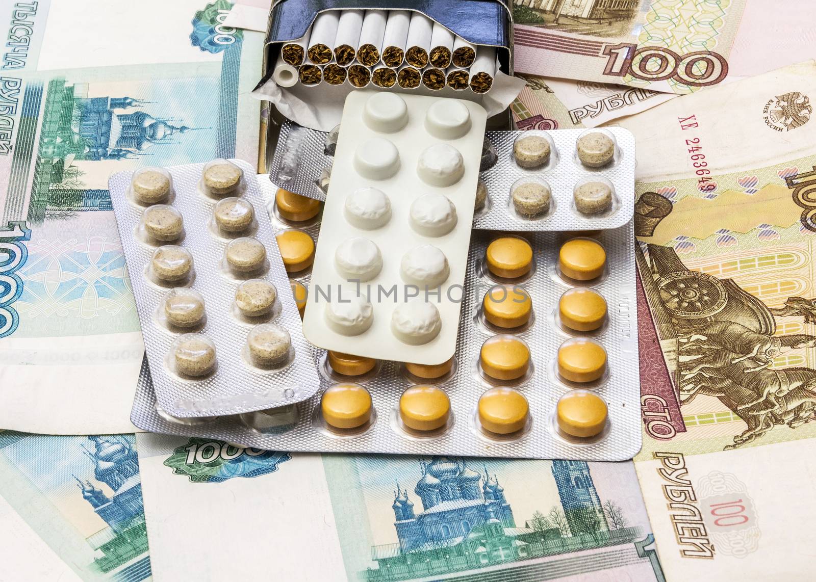 Cigarettes and medical drugs lie on banknotes by Grommik