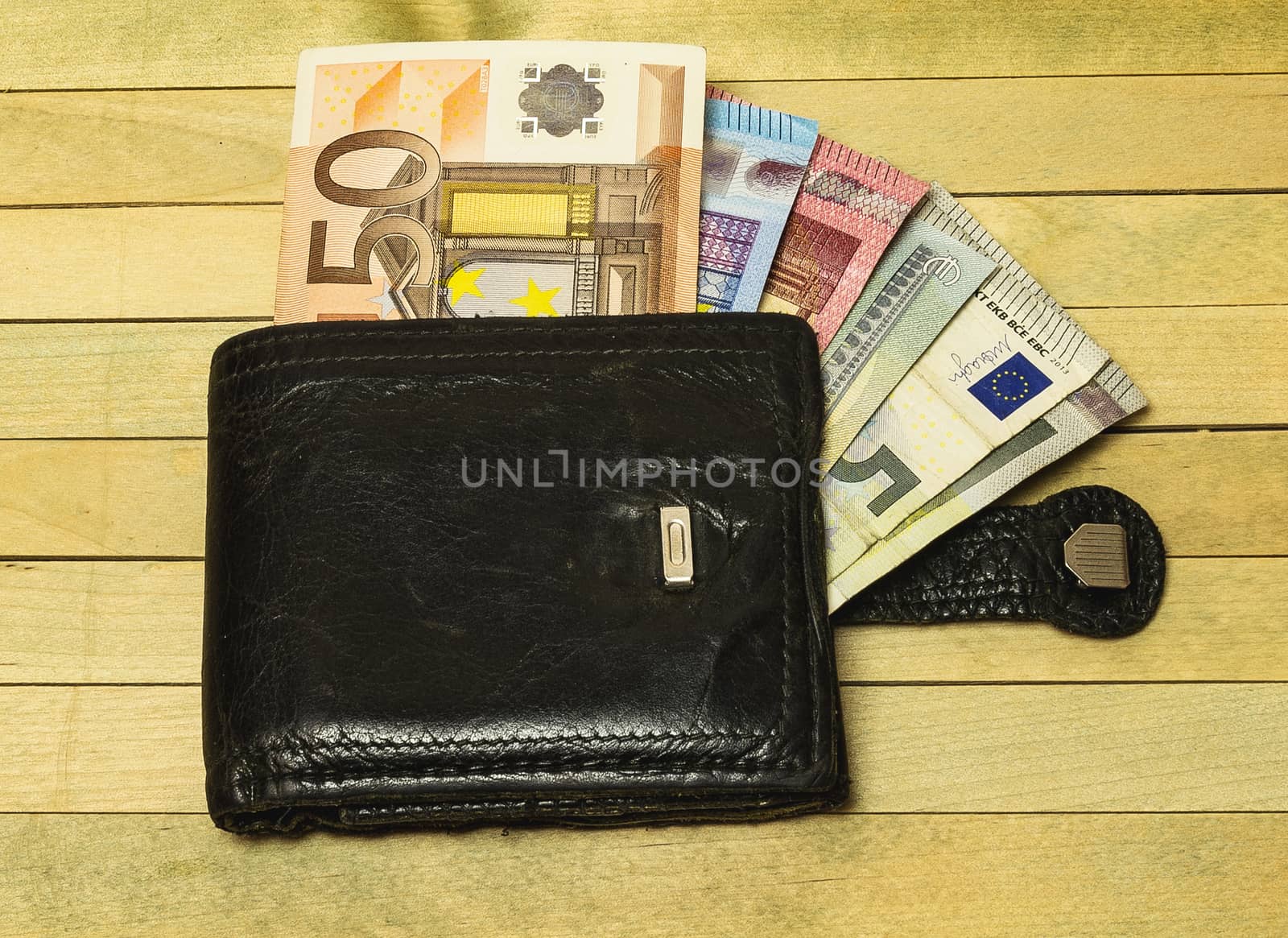 Leather purse lying on a wooden surface by Grommik