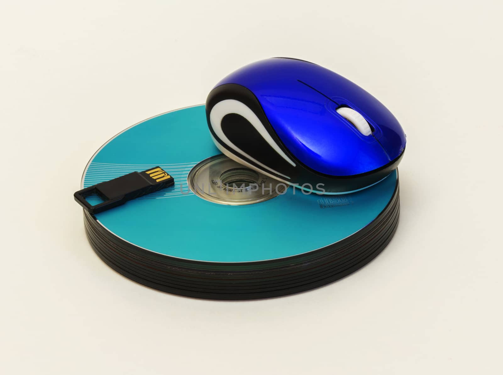 Computer mouse and USB flash lie on a stack of CD / DVD disk by Grommik