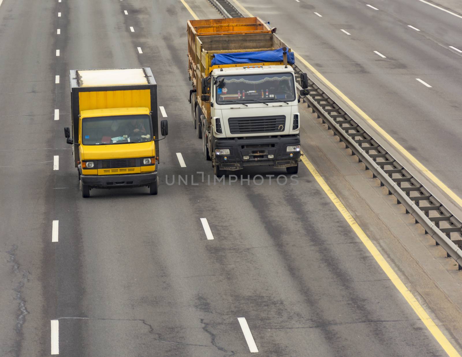 Tipper large mass and a van traveling on the motorway by Grommik