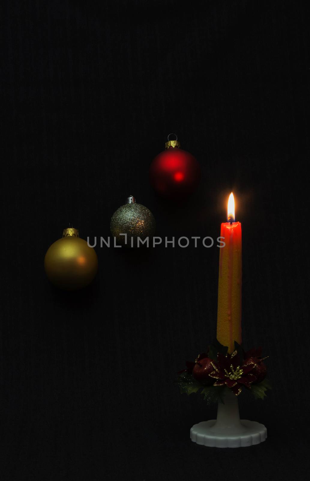 Candle and colorful balloons create a Christmas and New Year mood