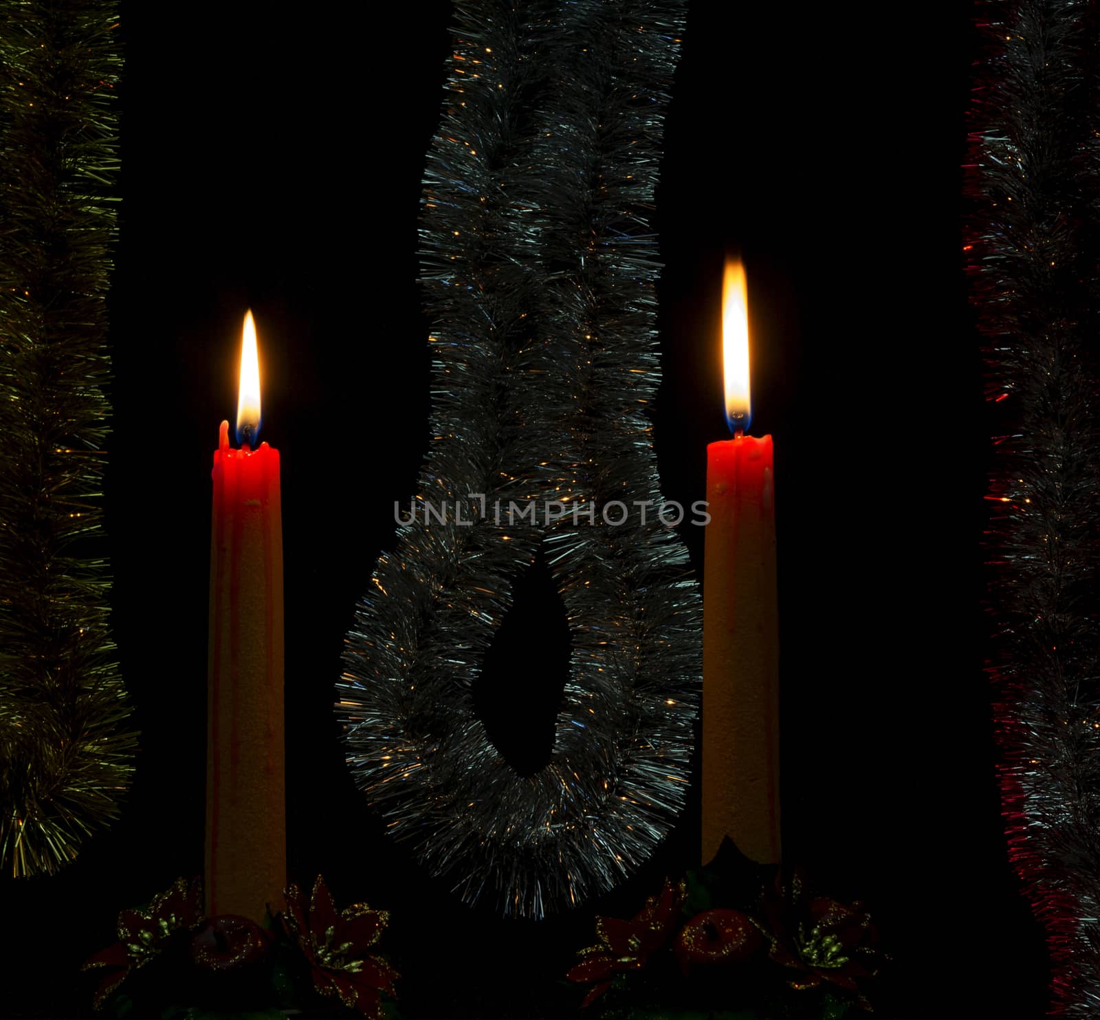 Two holiday candles burning in a romantic festive atmosphere
