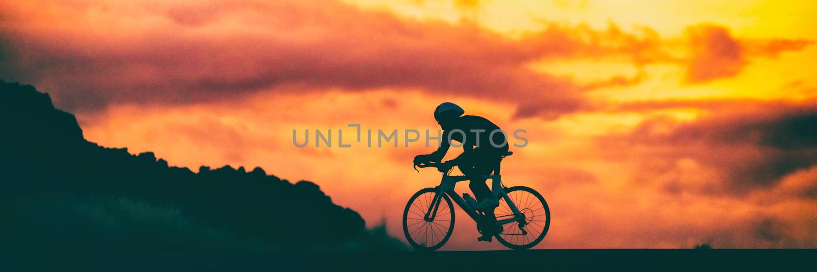 Road bike triathlon race cyclist on racing bike biking competition at sunset background sky banner panorama by Maridav