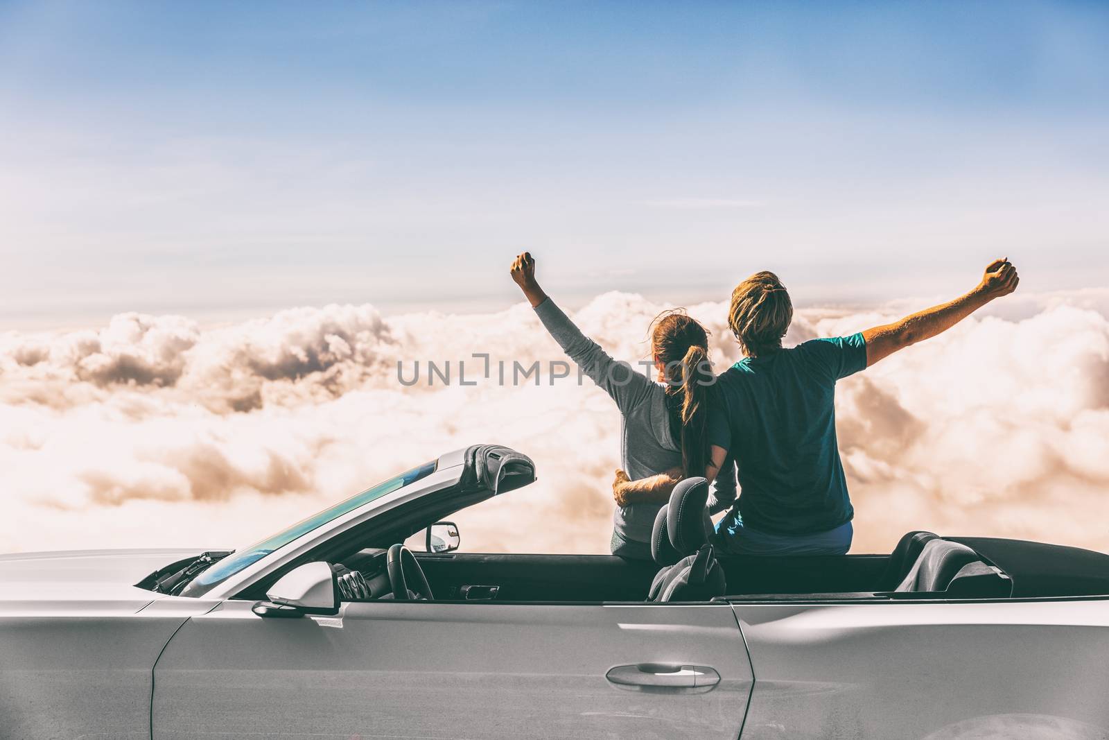 Happy car road trip couple freedom on summer travel vacation driving convertible sports car feeling excited winning free by Maridav