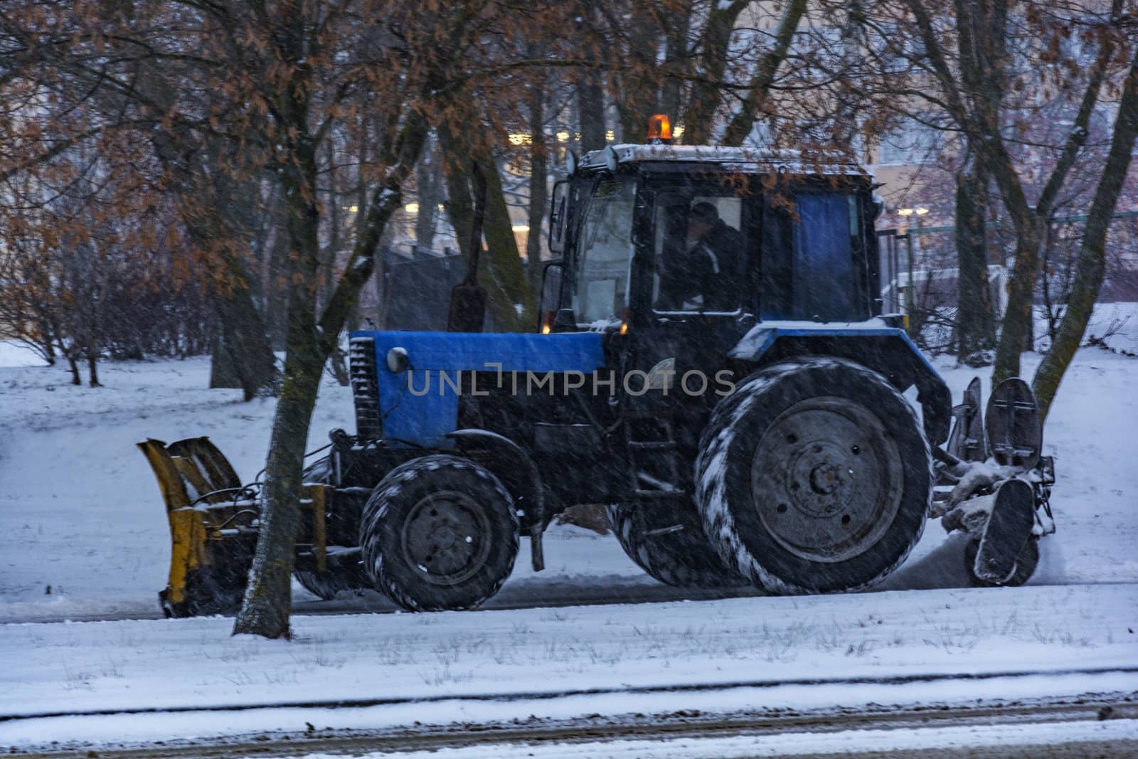 Traktor Balorus rensar snö från trottoaren under snöfall