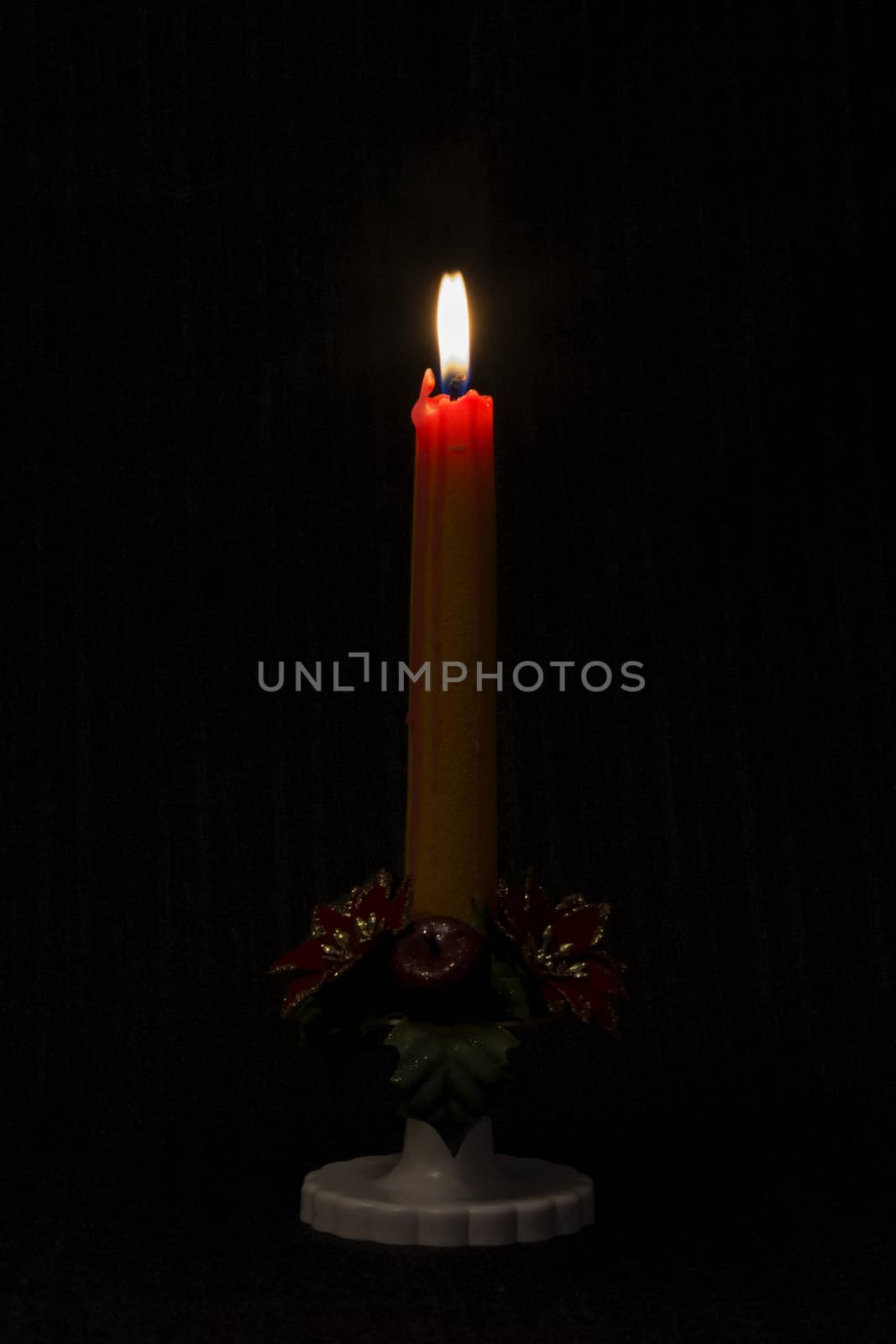 Lit candle on black background