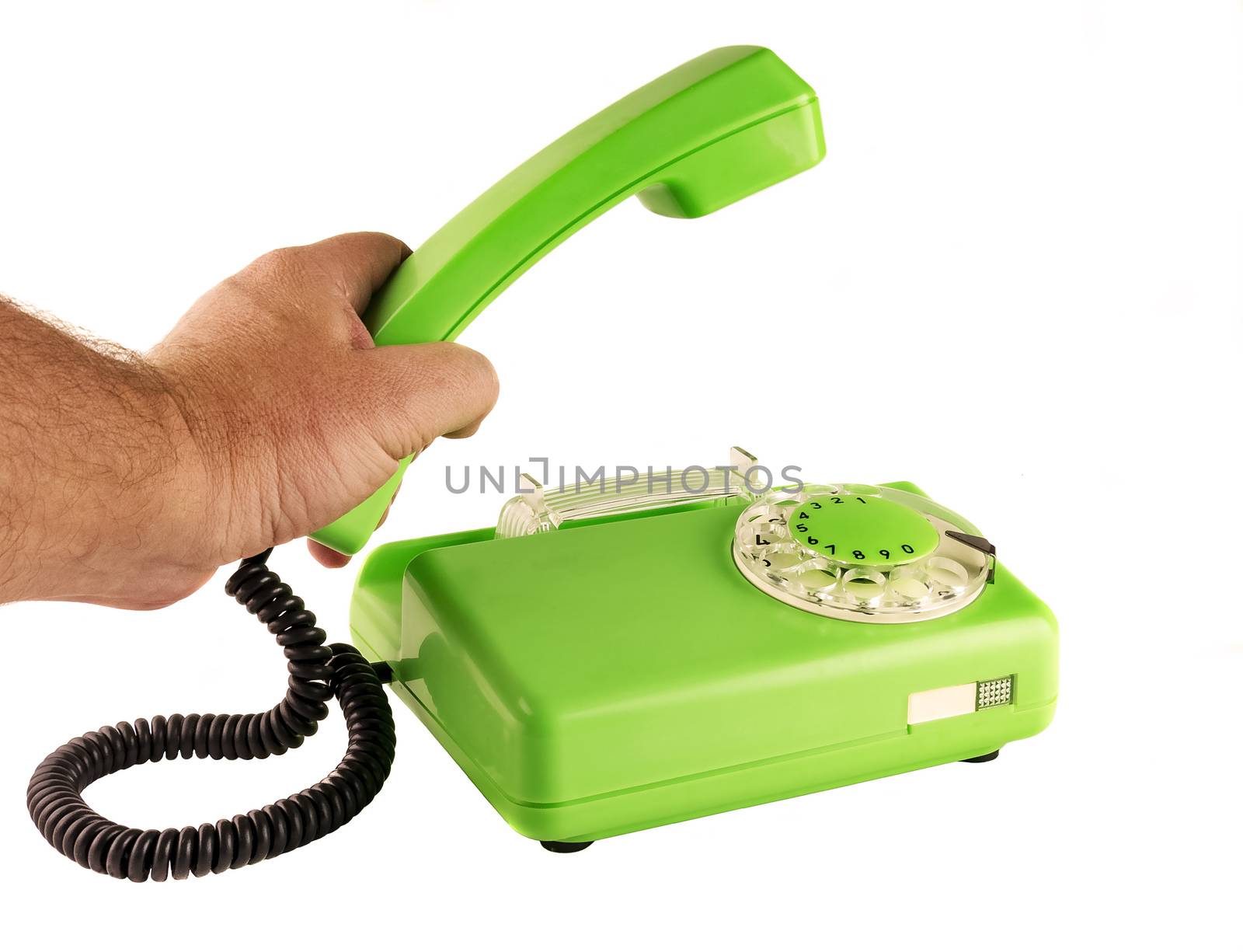 On a white background male hand holding a green telephone handset rotary dialer