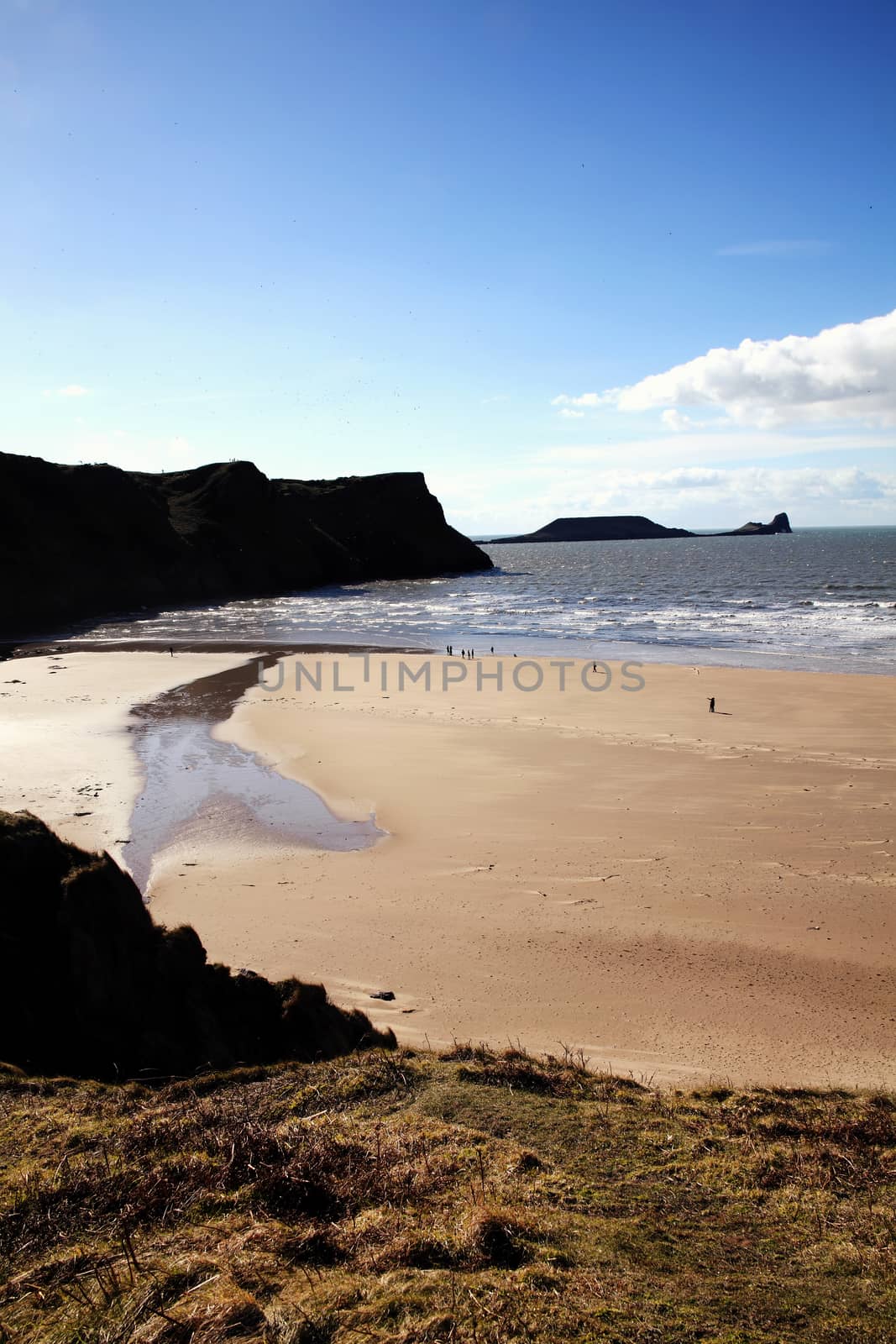 Worm's Head as seen from Rhossili Bay on the Gower Peninsular West Glamorgan Wales UK a popular Welsh coastline landmark attraction for a visitor travel destination of outstanding beauty stock photo