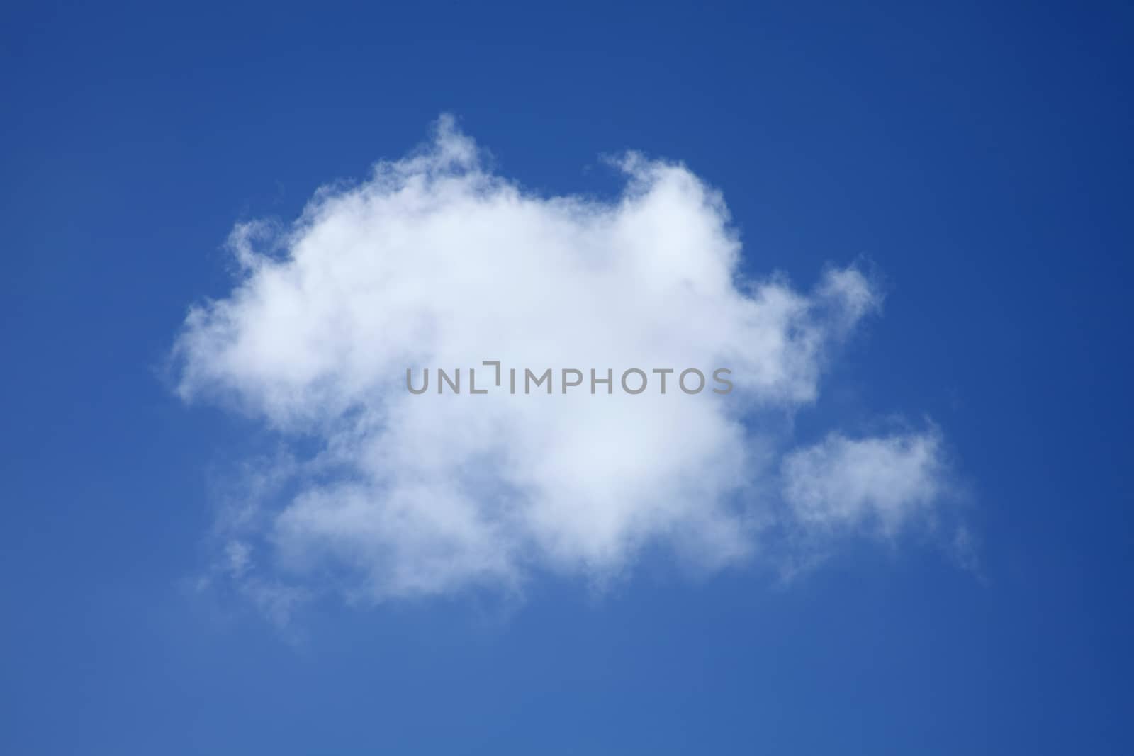 Background of a one single fluffy cumulus cloud in a blue clear sky which could be used to make a smoke brush stock photo