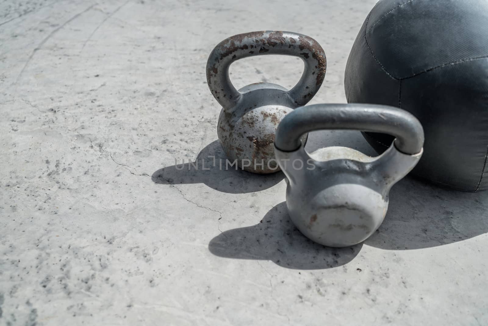 Gym kettlebell weight and medicine ball. Closeup of grunge background weights on concrete floor. Fitness and a healthy lifestyle