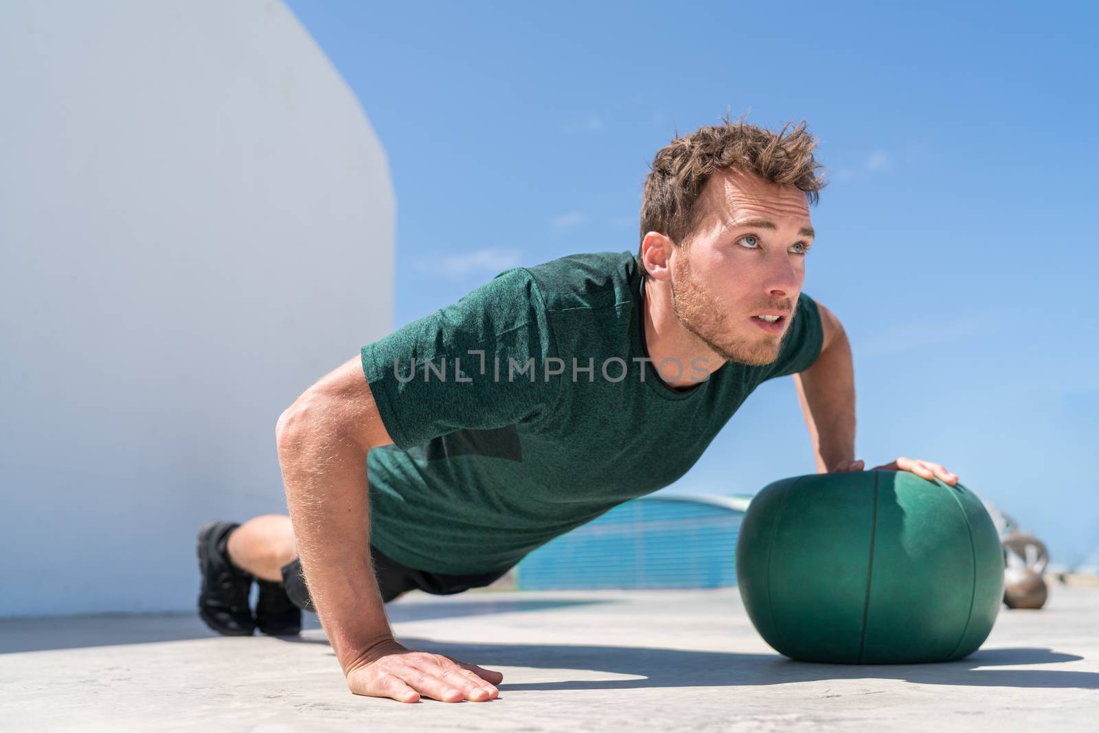 Push-up athlete strength training on medicine ball by Maridav