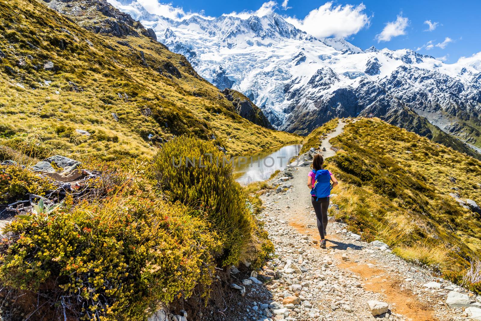 New zealand hiking girl hiker on Mount Cook Sealy Tarns trail in the southern alps, south island. Travel adventure lifestyle tourist woman walking alone on Mueller Hut route in the mountains by Maridav