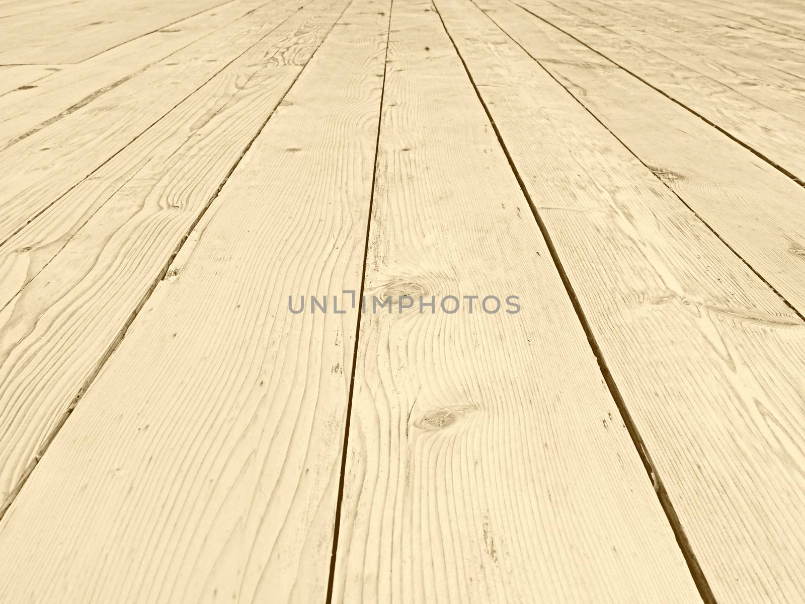 a full frame perspective view of old faded timber planking with a grainy textured surface used for flooring