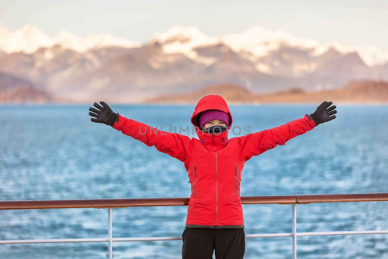 Alaska Glacier bay cruise travel fun tourist excited looking at inside passage. Happy woman with open arms in joy of seeing Alaskan nature landscape in the USA by Maridav