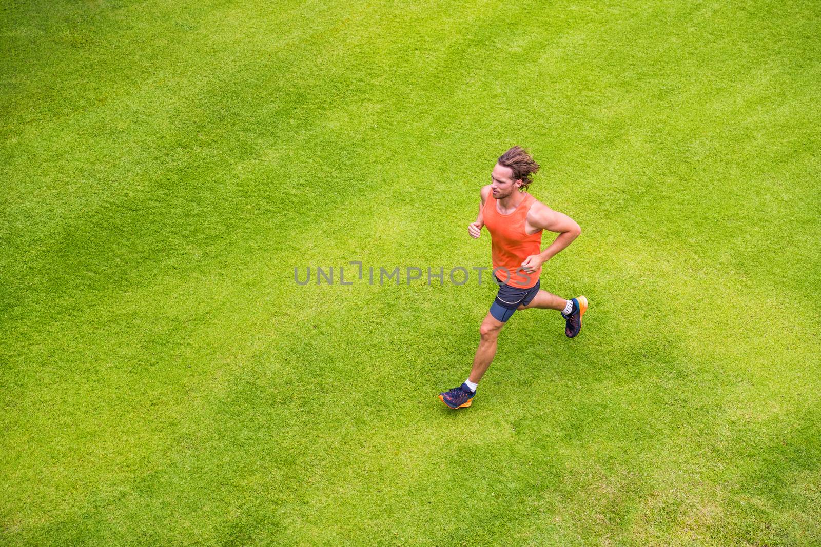 Jogging man training cardio morning run routine on grass park summer. Running runner active lifestyle - View from above.