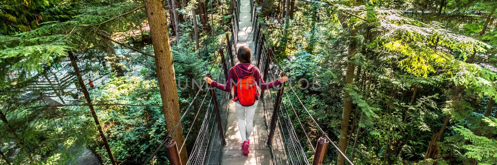 Canada travel people lifestyle banner. Tourist woman walking in famous attraction Capilano Suspension Bridge in North Vancouver, British Columbia, canadian vacation destination for tourism by Maridav