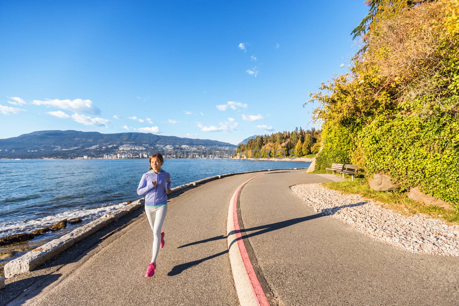 Runner girl running in Stanley Park Vancouver, British Columbia. Woman jogging in city outdoors enjoying healthy active lifestyle by Maridav