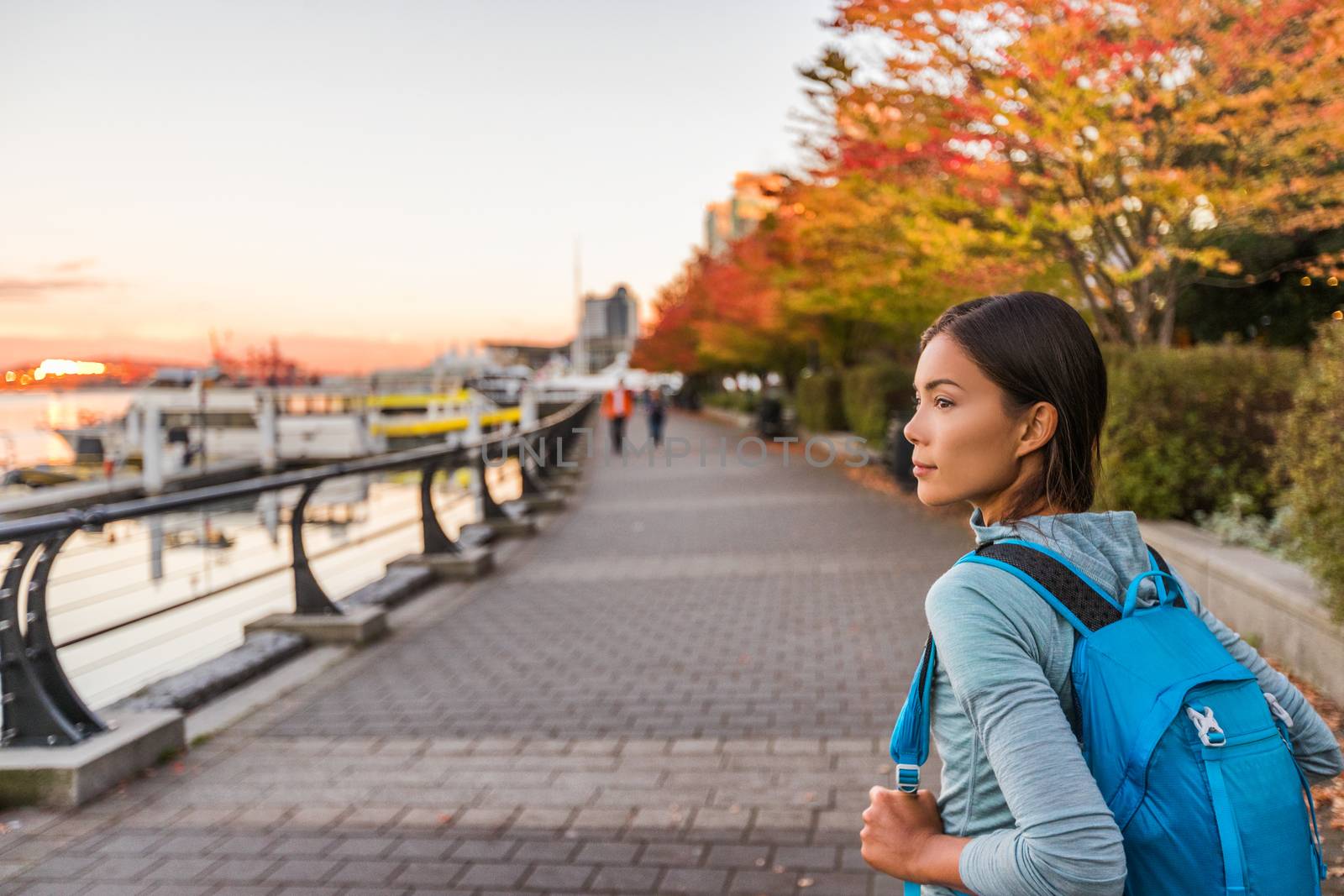 Vancouver city urban lifestyle people at Harbour, British Columbia. Woman tourist with student backpack in city outdoors enjoying autumn season by Maridav