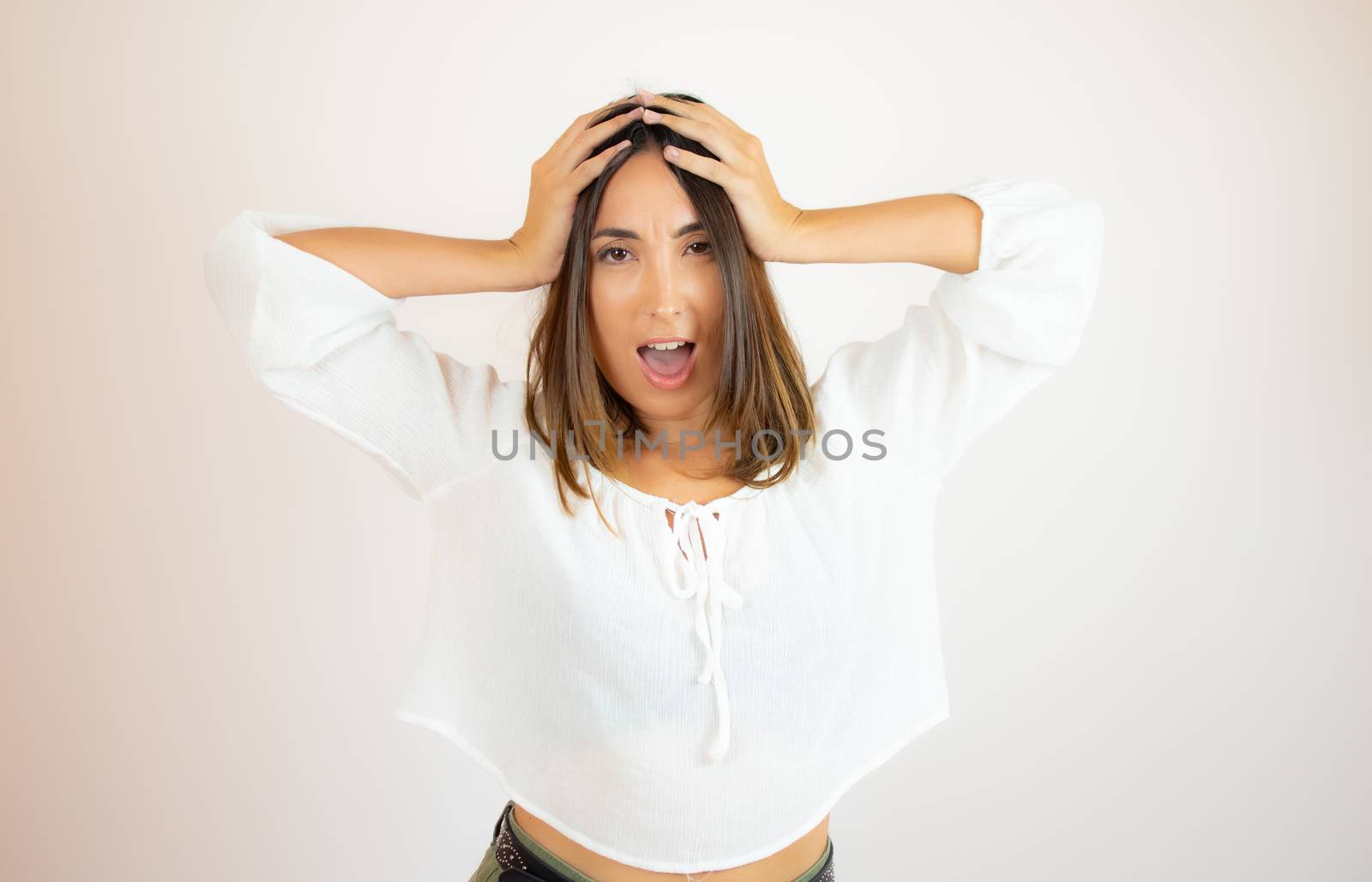 Beautiful young woman in white shirt surprised