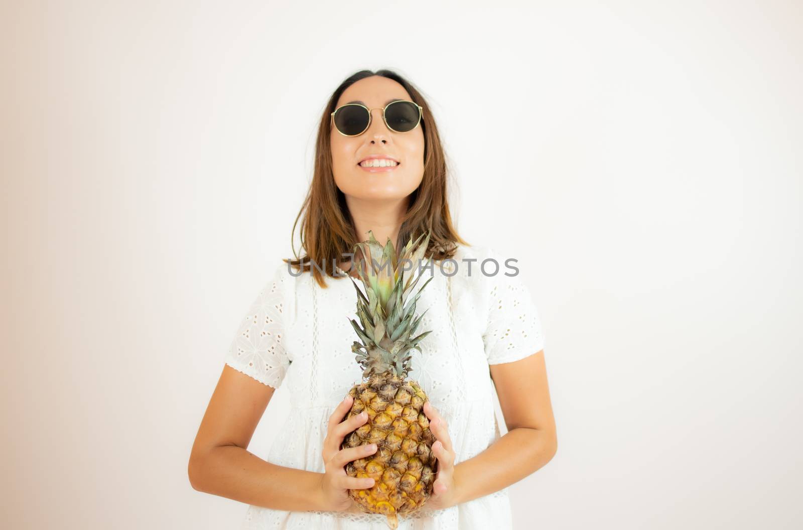 Beautiful young woman picking up a pineapple