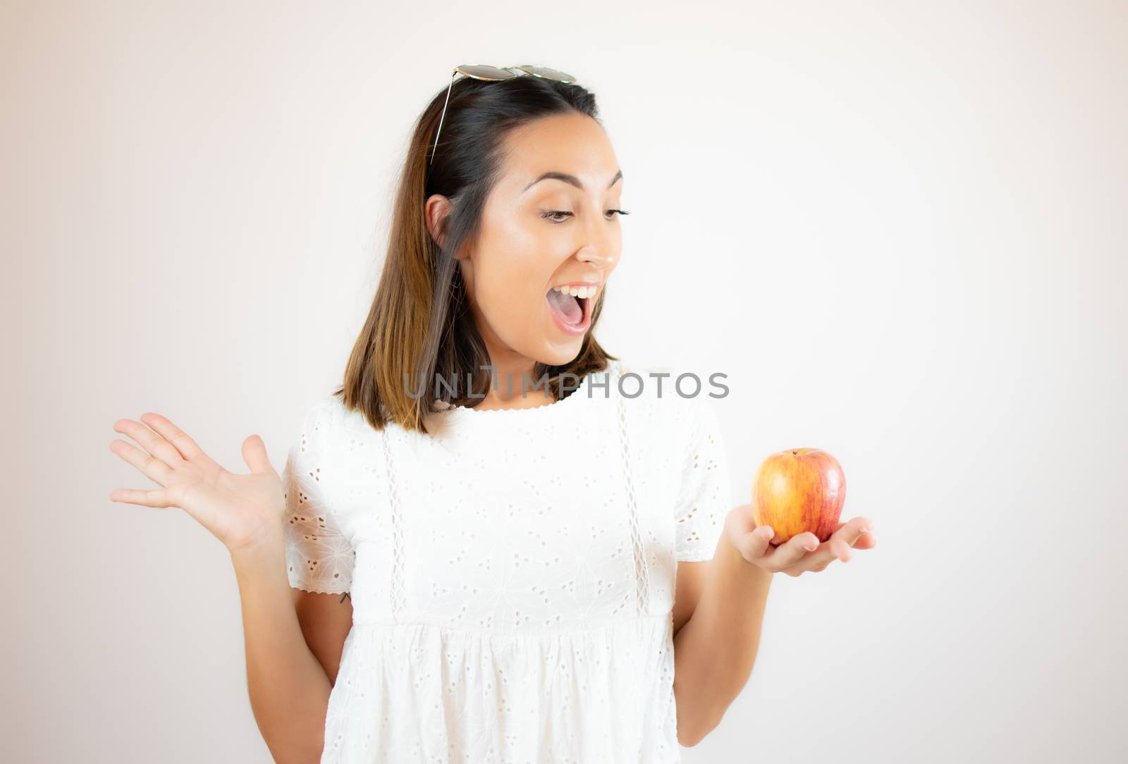 Beautiful young woman picking up an apple