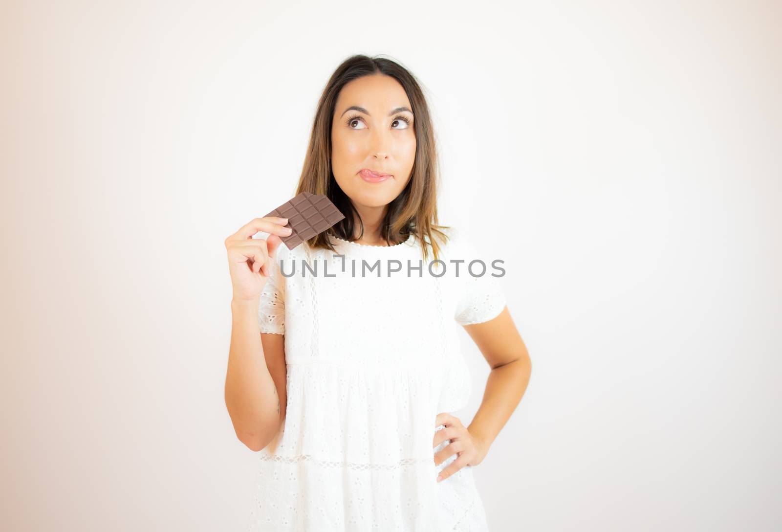 Beautiful young woman eating a piece of chocolate