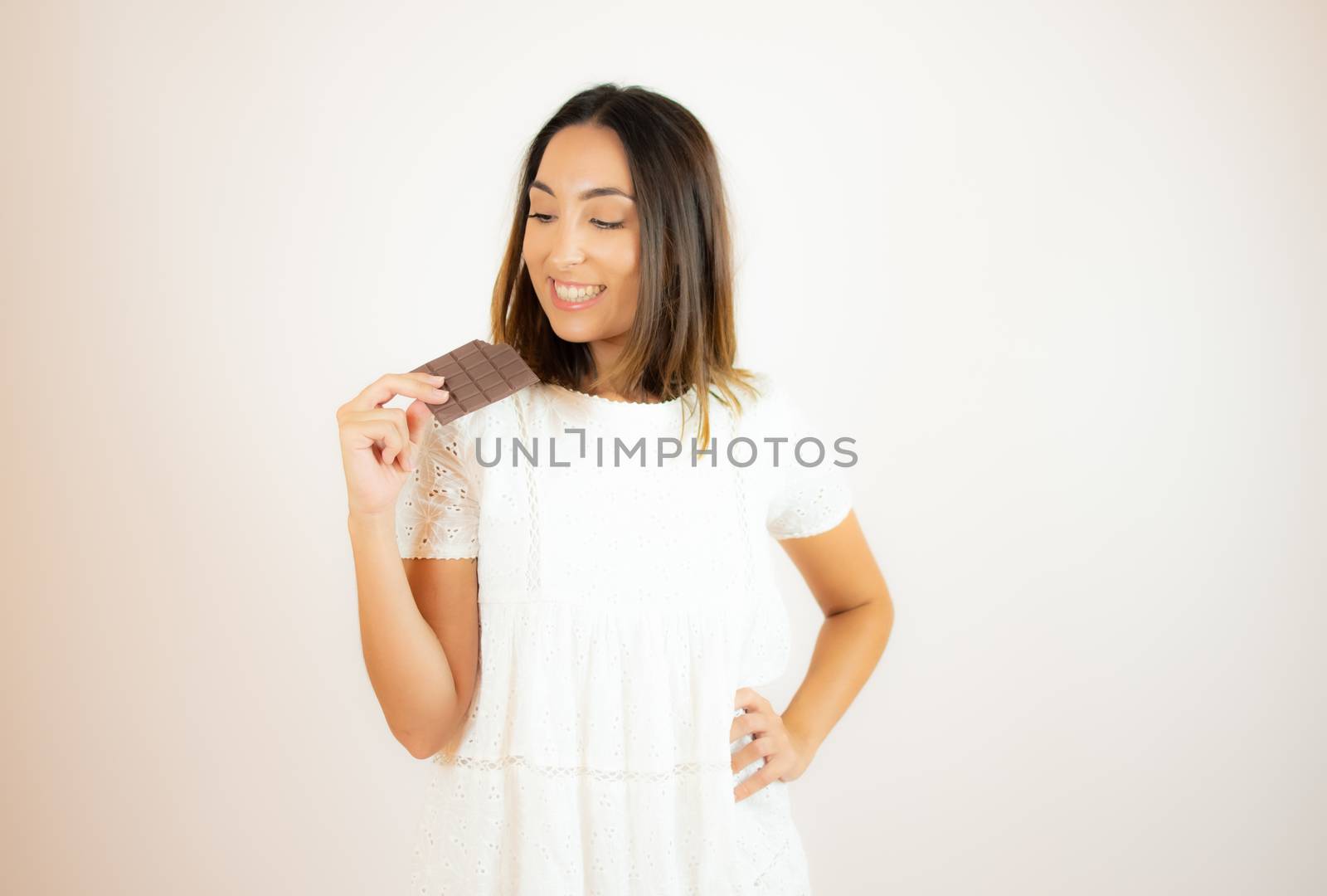 Beautiful young woman eating a piece of chocolate by lmstudio