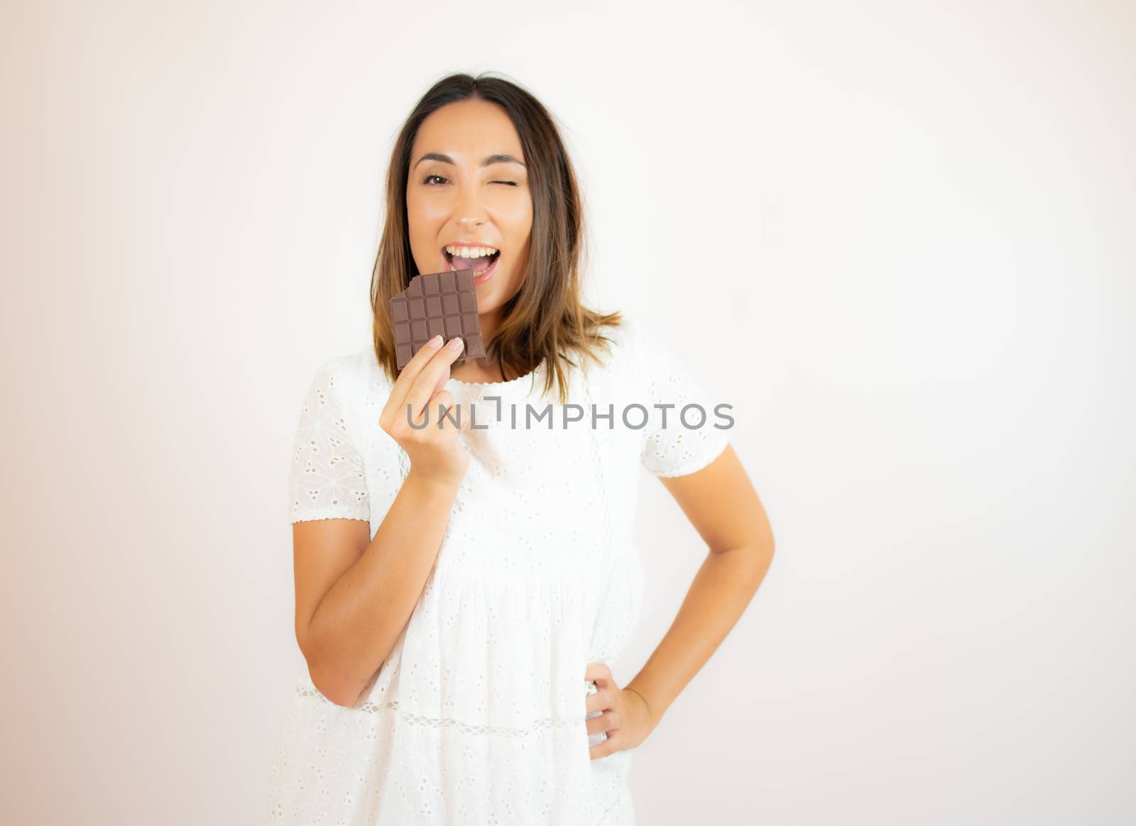 Beautiful young woman eating a piece of chocolate by lmstudio