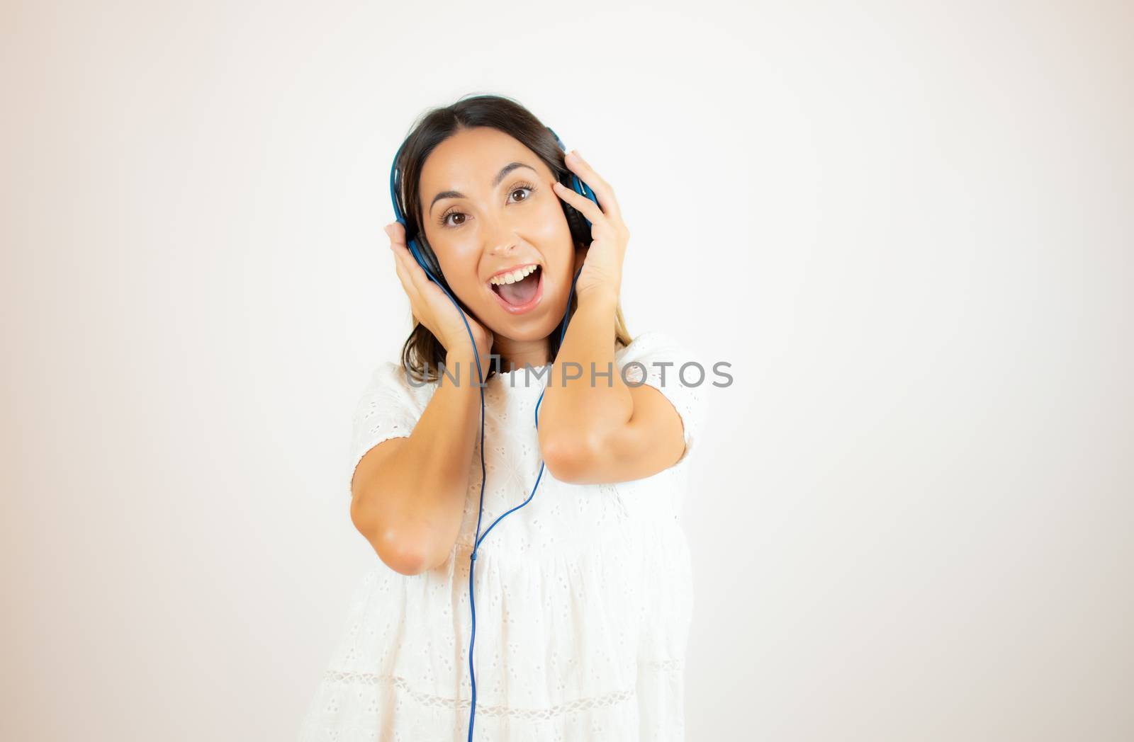Beautiful woman in white dress with headphones by lmstudio