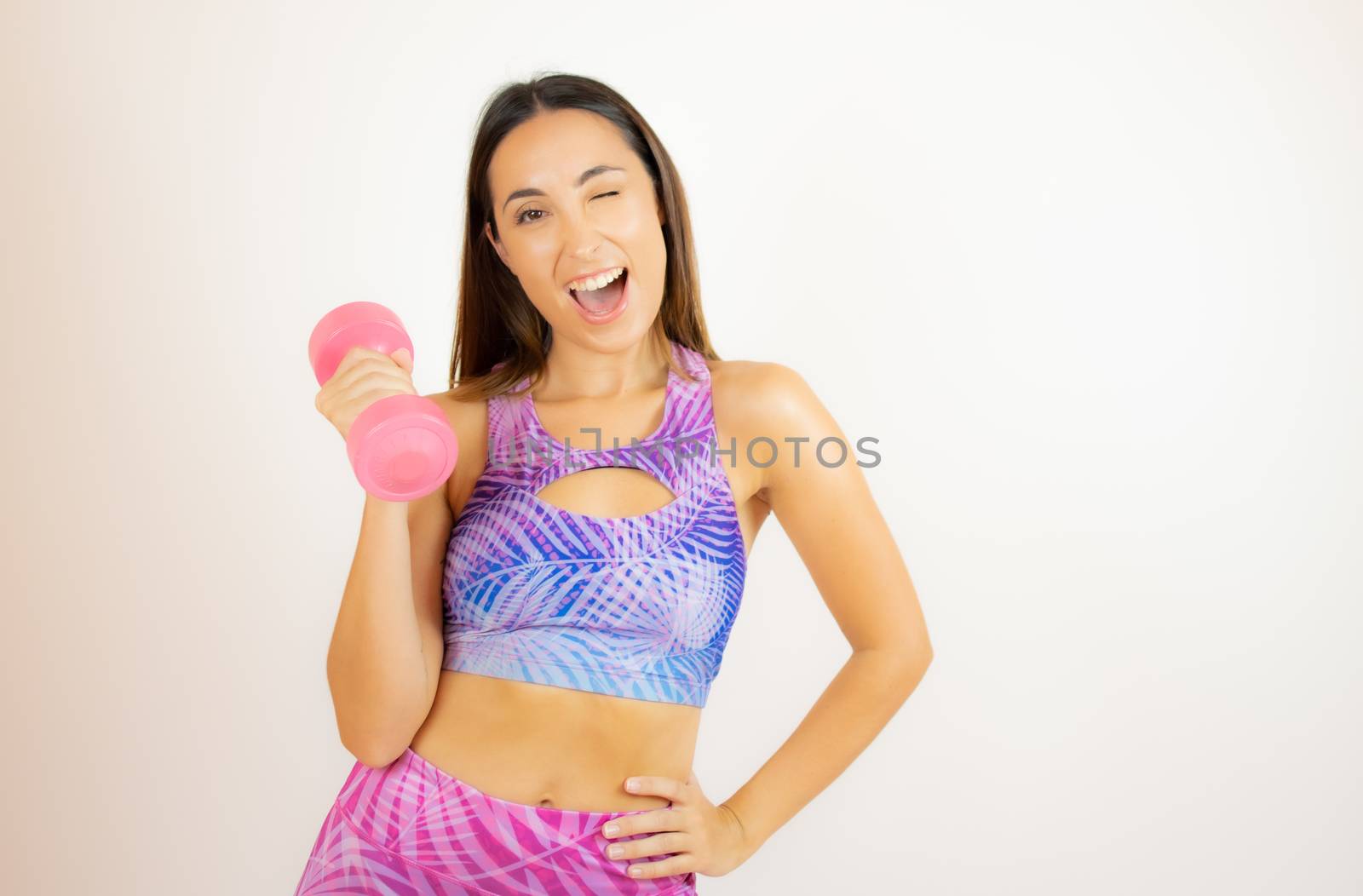 Beautiful woman with sports clothes with a dumbbell by lmstudio
