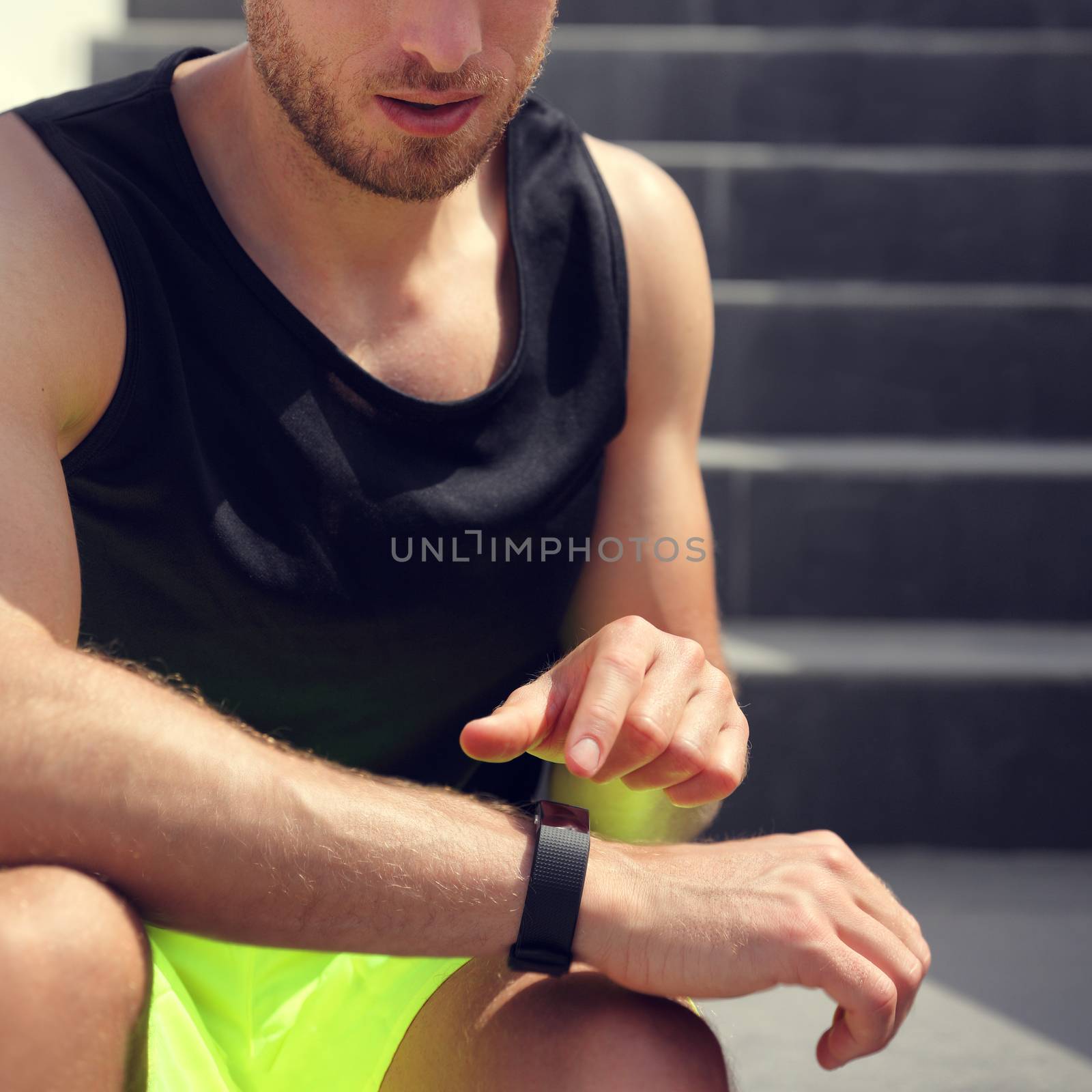 Smartwatch fitness man touching sports watch before running on stairs workout. Closeup of wrist and hand by Maridav