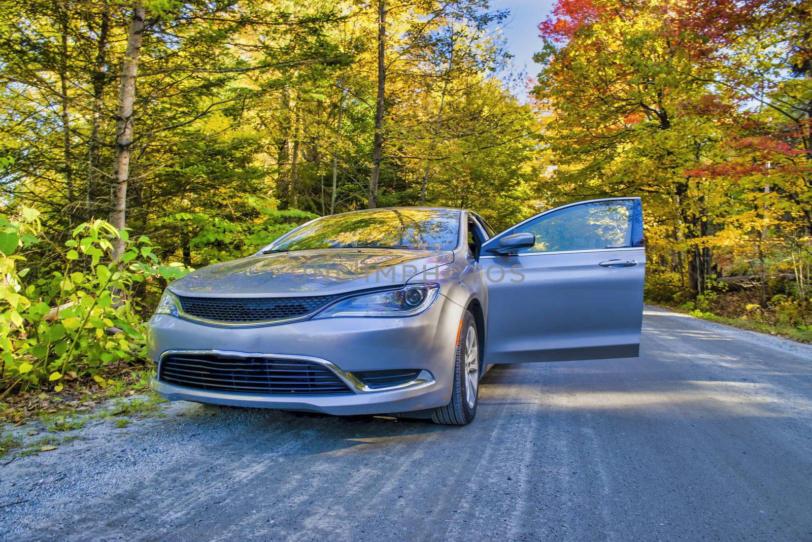 Car along a beautiful countryside road in foliage season.