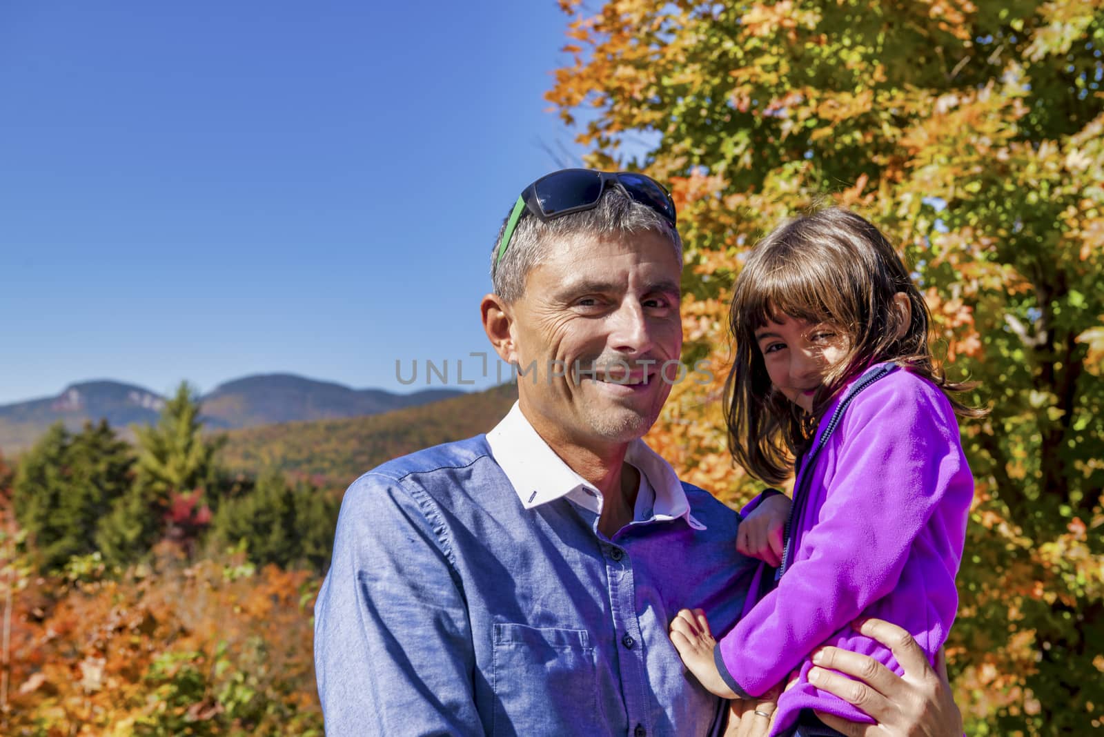 Happy man embracing his daughter on a beautoful foliage excursion.