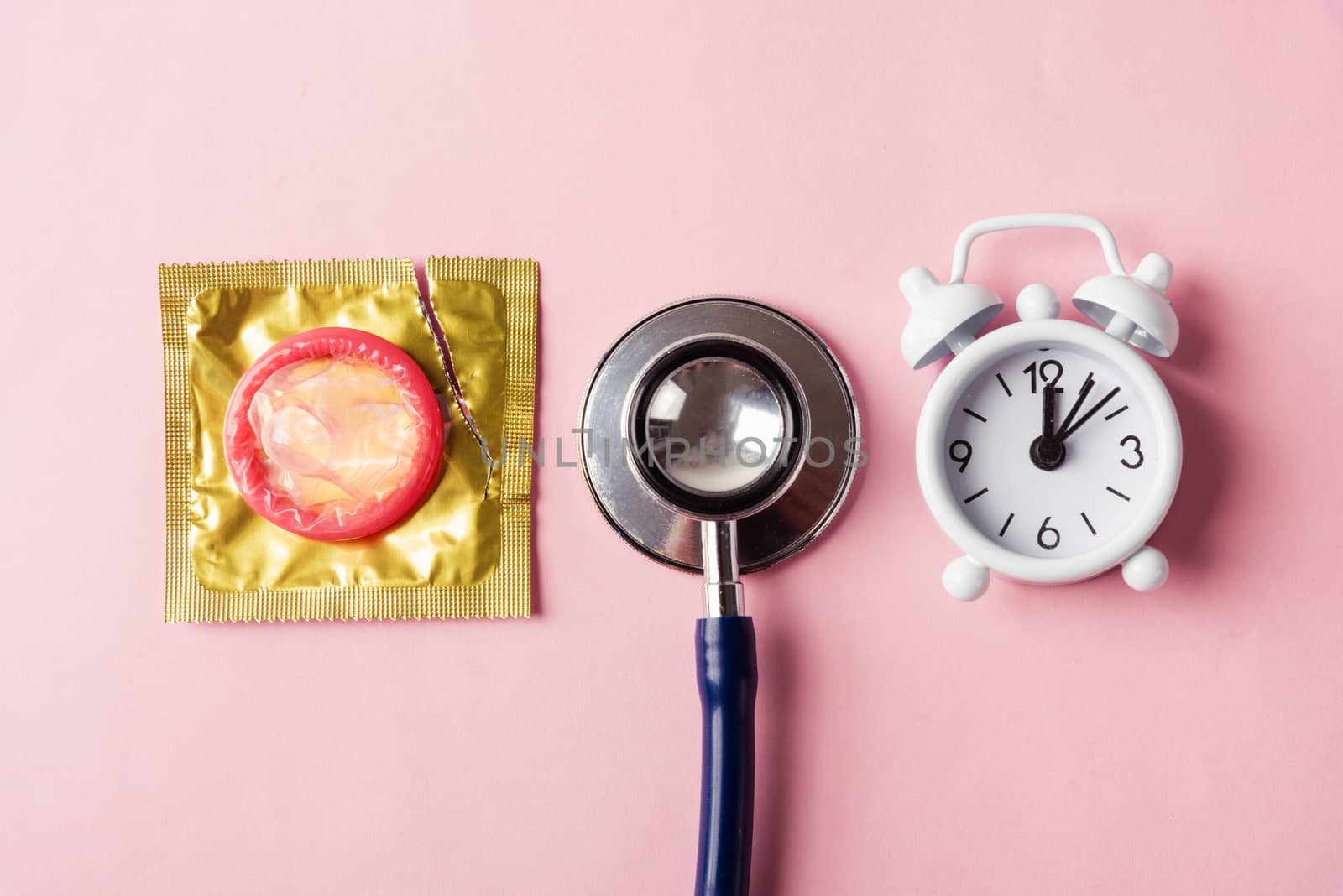 condom in a pack, stethoscope and alarm clock by Sorapop