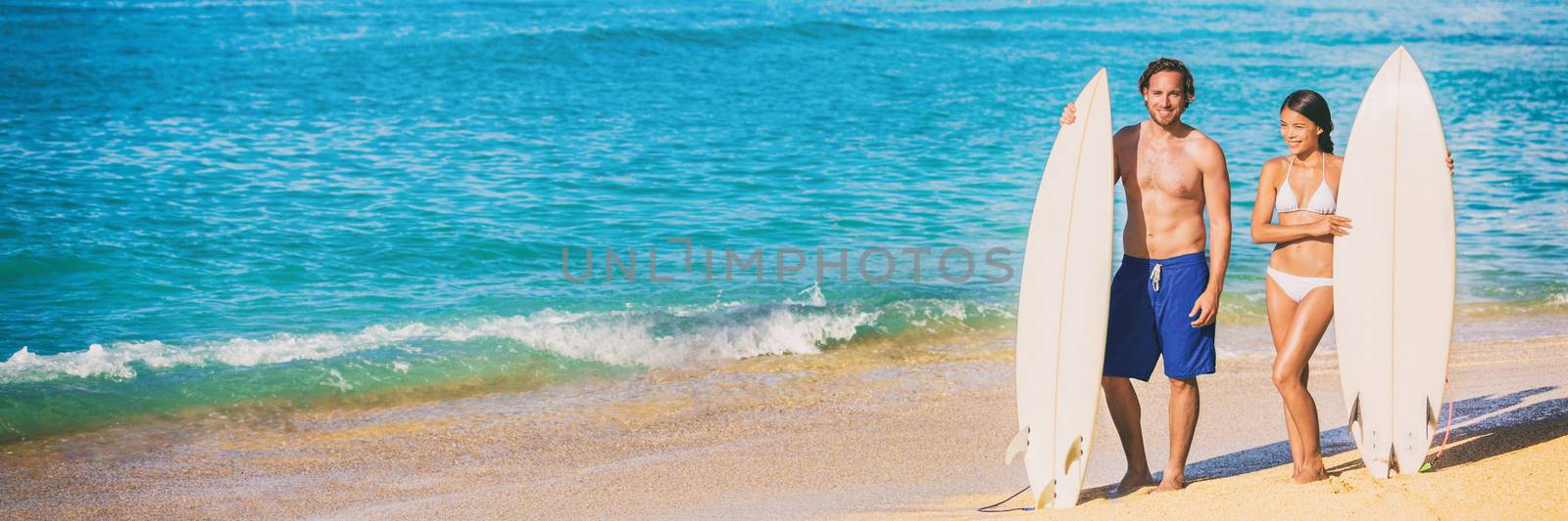 Beach surfing vacation banner surfers people fitness lifestyle couple with surfboards ready to surf on blue ocean background. Summer travel holidays.