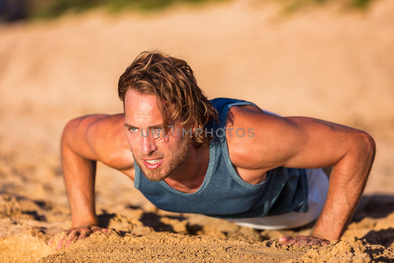 Push-up fitness man training pushups on beach doing bodyweight exercises for arms workout. Healthy lifestyle person working out muscles.