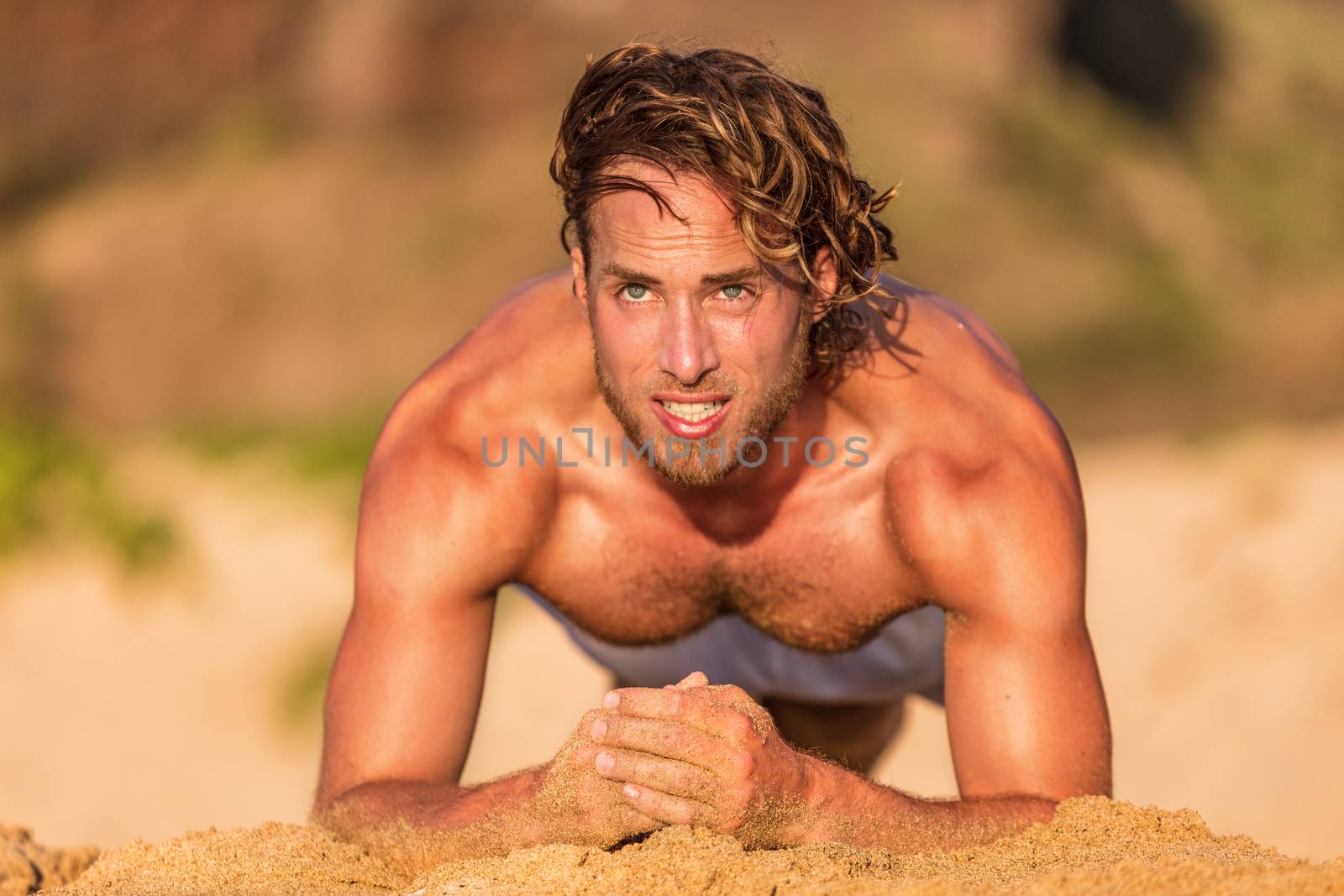 Fitness planking workout man doing plank exercise on beach at sunset. Sexy shirtless male athlete strength training sweating working out core body exercises.