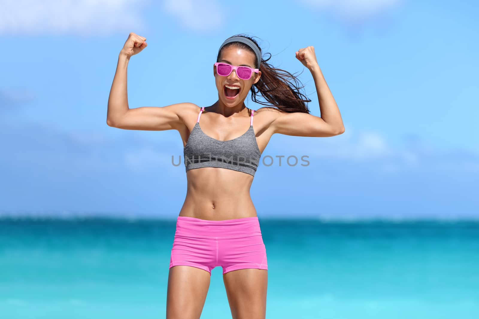 Strong fitness woman flexing biceps success by Maridav