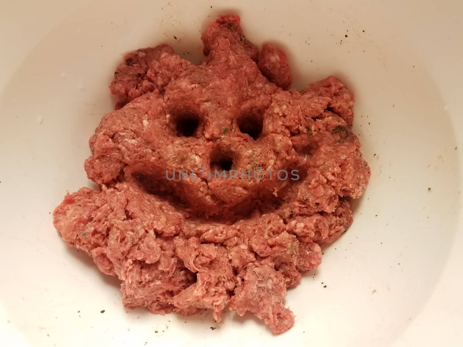 meat face with smile in raw beef in white container