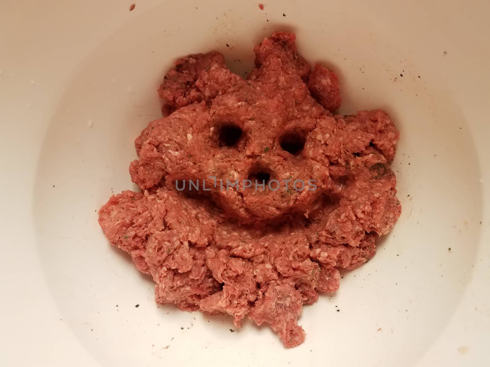 meat face with smile in raw beef in white container