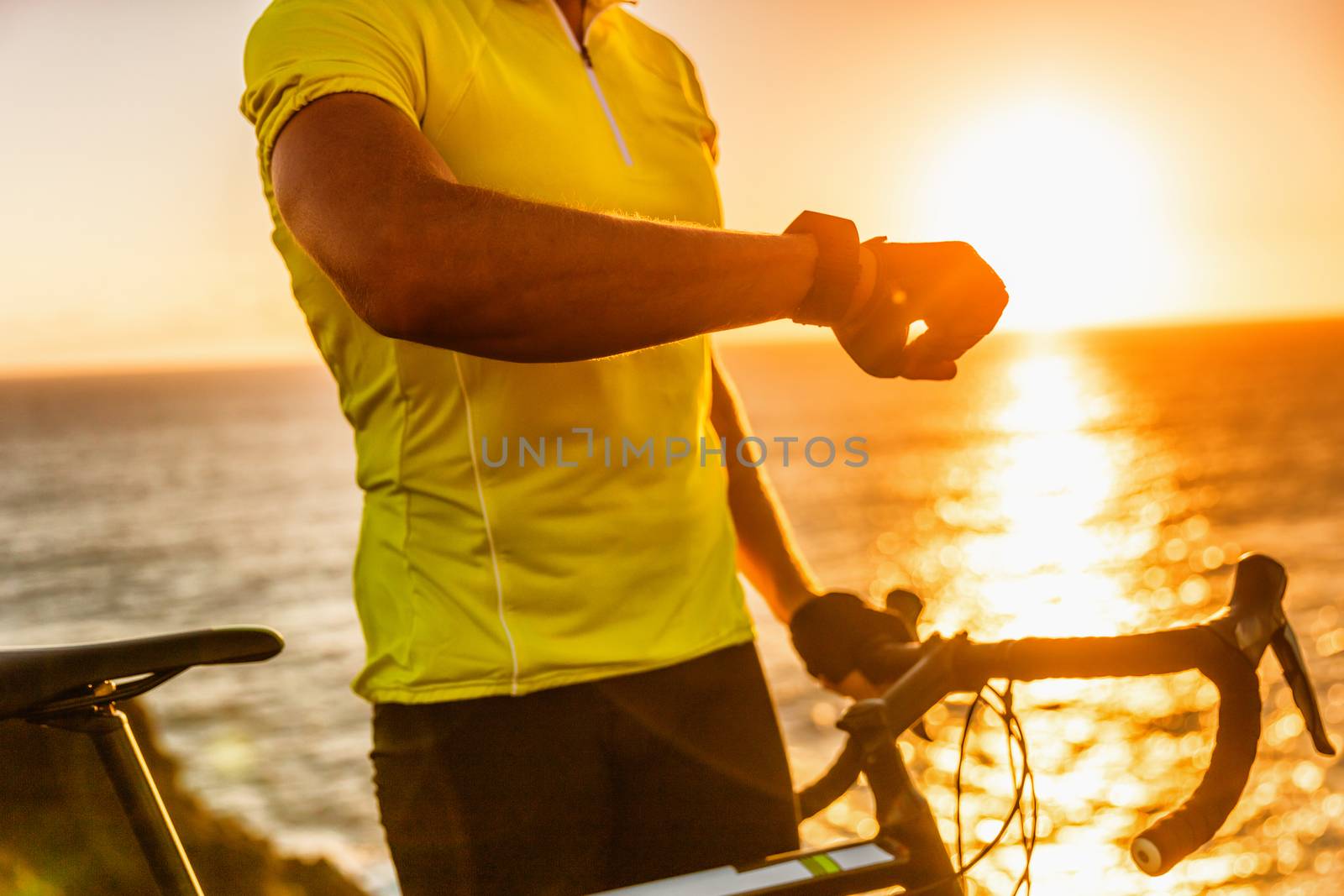 Smartwatch biking cyclist athlete using smart watch activity tracker gps during cycling training. Road bike sports man using his watch app for fitness tracking. Healthy lifestyle by Maridav